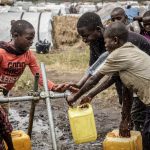Les enfants réfugiées puisant de l'eau au robinet