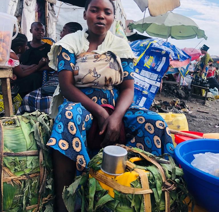 Une femme en pleine vente des boissons traditionnelles dans le camp de Bulengo